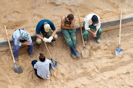 Sitting workers with shovels on the rest, fotolia